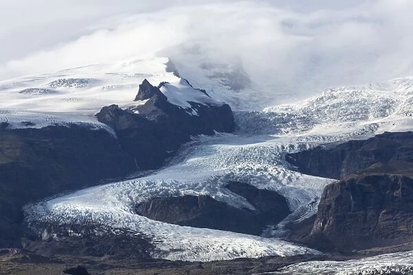 Tongue of the Vatnajokull Glacier creeping down the mountains behinf Fjallsarlon lagoon