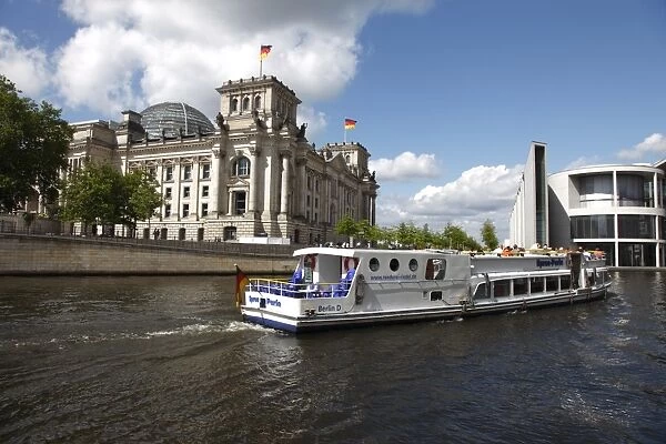 Tour boat on river cruise on the Spree River passing the Reichstag (Parliament)