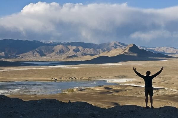 Tourist admiring the stunning scenery of Tuz Kul, Pamir, Tajikistan, Central Asia