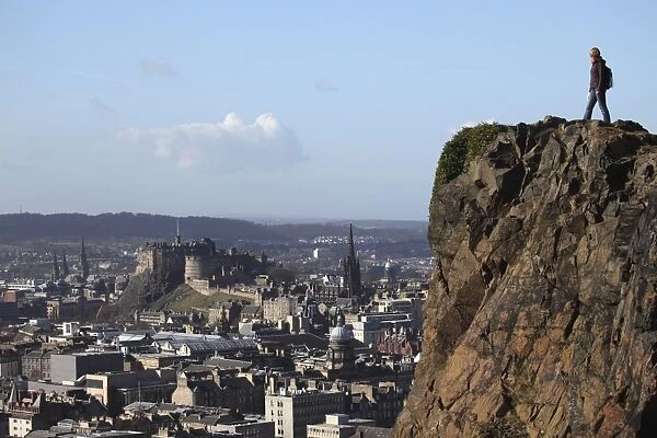 A tourist on Arthurs Seat looking towards the castle and skyline of Auld Reekie