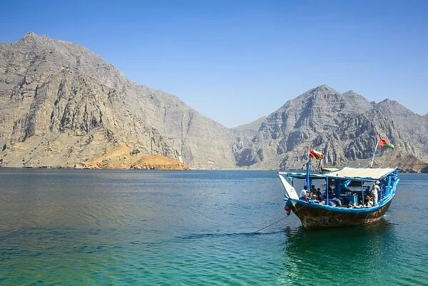 Tourist boat in form of a dhow sailing in the Khor ash-sham fjord, Musandam, Oman, Middle East