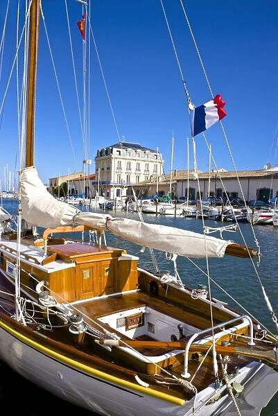 Tourist boats in marina, and French flag, in Marseillan harbor, Herault, Languedoc-Roussillon region, France, Europe