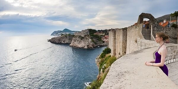 Tourist on Dubrovnik City Walls, with Fort Lovrijenac (St. Lawrence Fortress) in the background, Dubrovnik, Dalmatian Coast, Adriatic, Croatia, Europe
