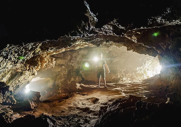 Tourist exploring the Ana Kakenga Cave, Rapa Nui National Park, UNESCO World Heritage Site