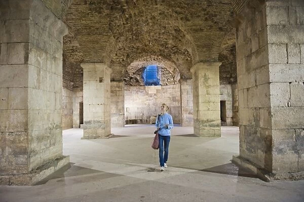 Tourist exploring the underground halls at Diocletians Palace, UNESCO World Heritage Site, Split, Dalmatian Coast, Croatia, Europe