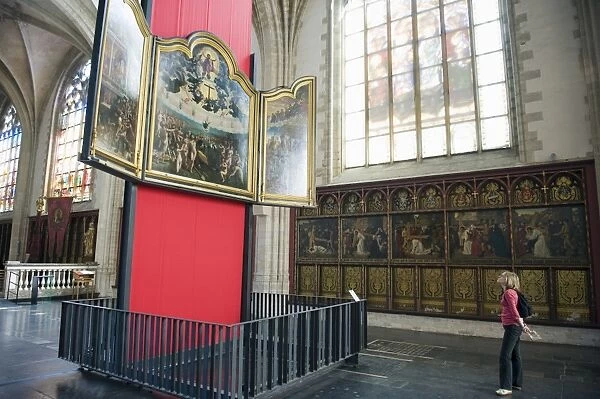 Tourist looking at a canvas by Rubens, in Onze Lieve Vrouwekathedraal, Antwerp