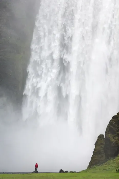 Framed Print : Tourist in red jacket at Skogafoss waterfall