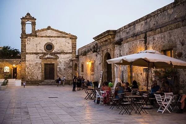 Tourist at a restaurant, Church of St Francis of Paolo in the main square, Marzamemi, Sicily, Italy, Europe
