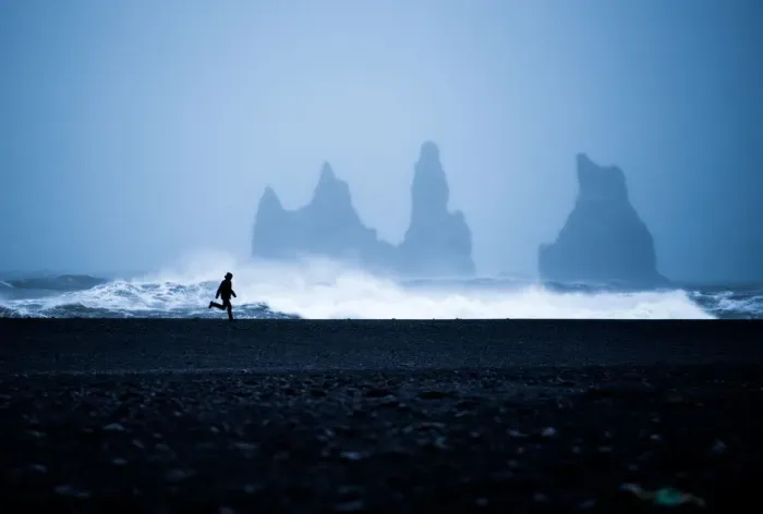 Framed Print : Tourist running on Black Sand Beach, Iceland, Polar Regions Framed Print : Tourist running on Black Sand Beach, Iceland, Polar Regions