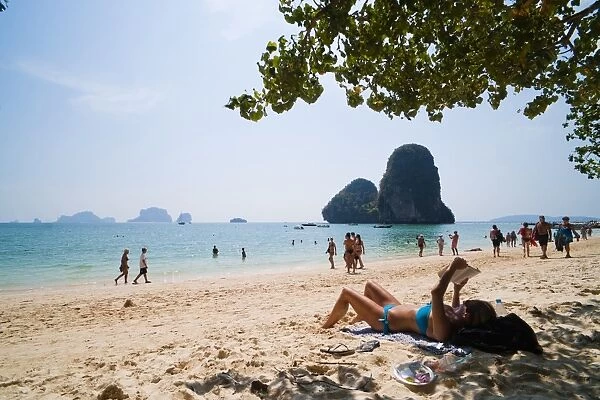 Tourist sunbathing and reading on Ao Phra Nang Beach, Railay (Rai Leh), South Thailand, Southeast Asia, Asia