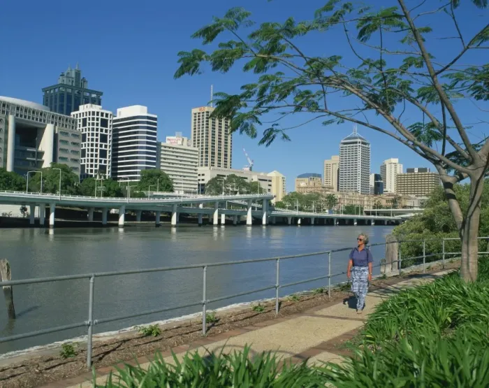 Framed Print : Tourist walking beside the Brisbane River and the city skyline behind, Brisbane Framed Print : Tourist walking beside the Brisbane River and the city skyline behind, Brisbane