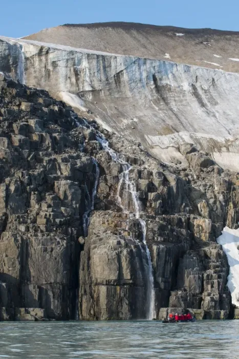 Framed Print : Tourist in a zodiac looking at Waterfall dropping in the ocean, Alkerfjellet, Svalbard, Arctic Framed Print : Tourist in a zodiac looking at Waterfall dropping in the ocean, Alkerfjellet, Svalbard, Arctic