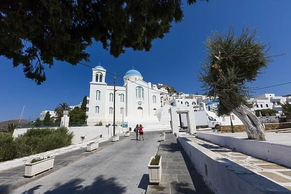 Tourists admire the architecture of Orthodox churches colored white and blue as symbols of Greece
