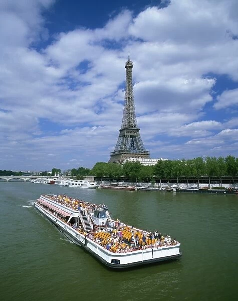 Tourists on bateau mouche on the River Seine with the Eiffel tower in the background