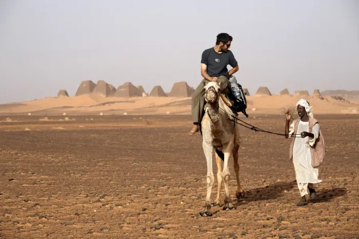 Framed Print : Tourists take camel rides at the pyramids of Meroe Framed Print : Tourists take camel rides at the pyramids of Meroe