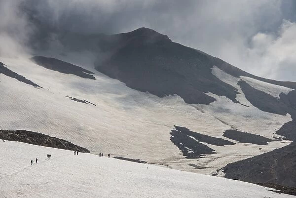Tourists crossing a snowfield, Mutnovsky volcano, Kamchatka, Russia, Eurasia