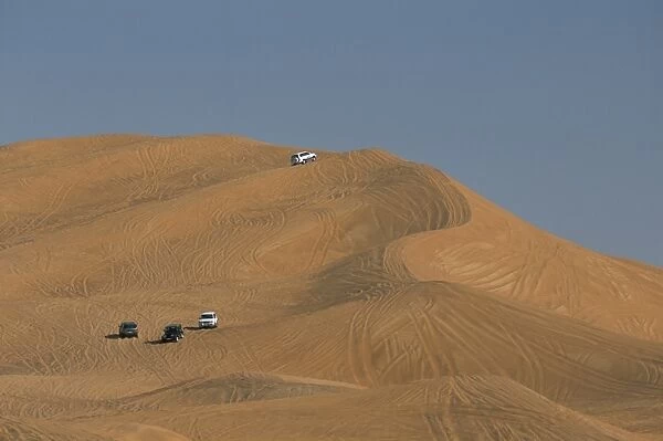 Tourists dune-bashing in 4 wheel drive vehicles in