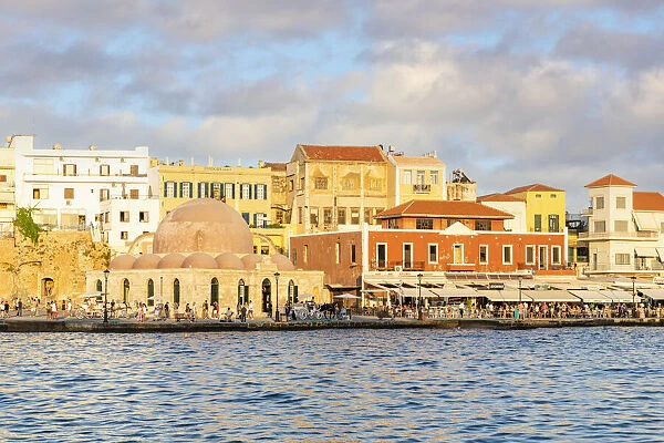 Tourists enjoying sunset at the old Venetian port of Chania, Crete, Greek Islands, Greece