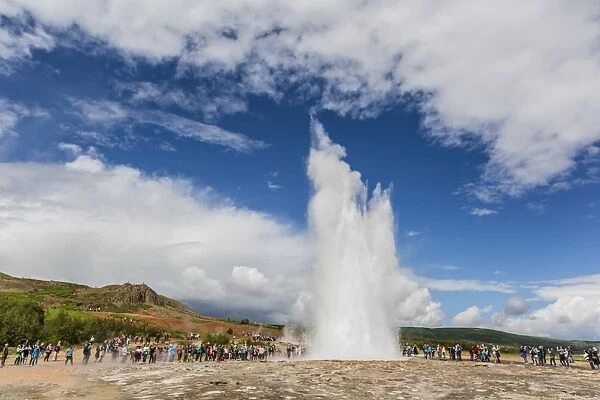 Tourists gather to watch Strokker geyser (geysir), an erupting spring at Haukadalur