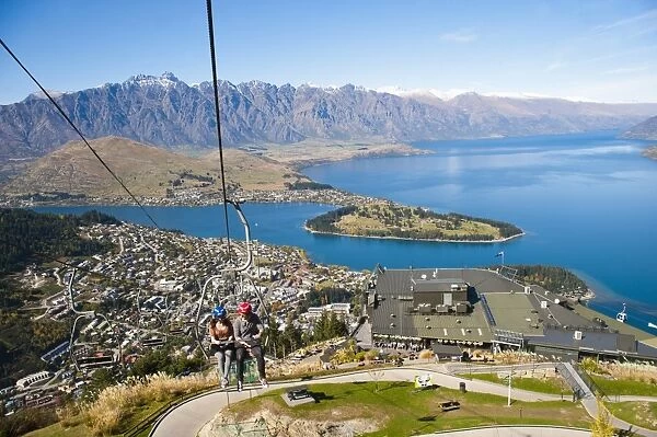 Two tourists on the gondola to the luge track above Queenstown, Otago, South Island, New Zealand, Pacific