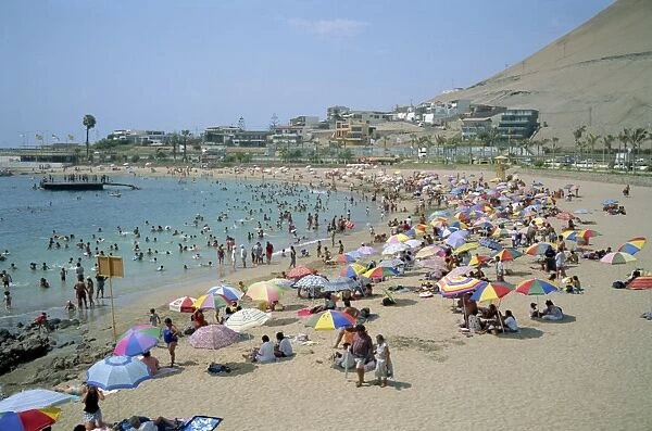 Tourists and holidaymakers crowd the beach at Playa La Lisera, in Arica