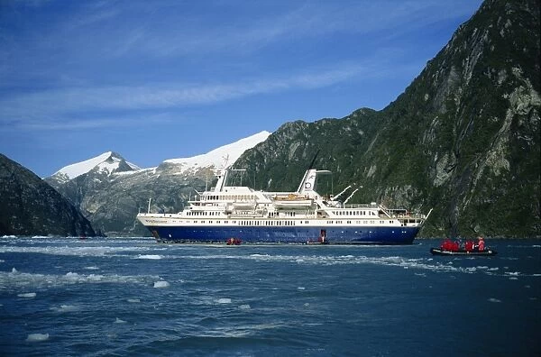 Tourists in an inflatable boat and cruise ship in the Chilean fjords, Chile