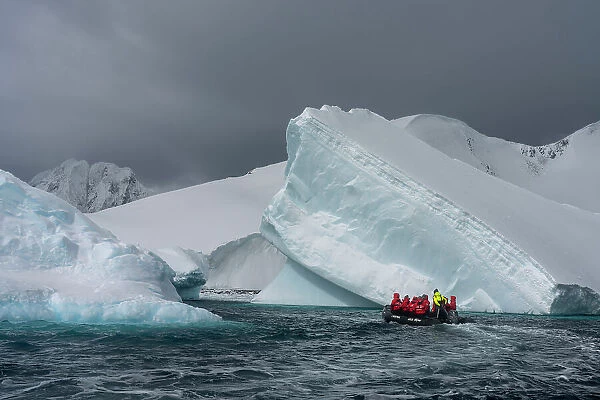 Tourists in an inflatable boat exploring Pleneau Island, Antarctica, Polar Regions