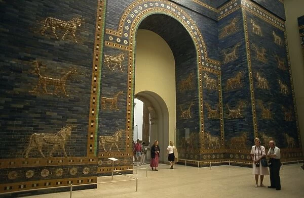 Tourists listen to recorded description of Ishtar Gate, Babylonian dating from the 6th century BC