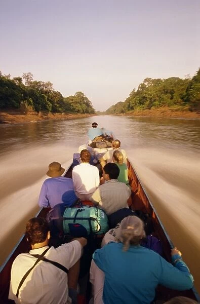 Tourists in longboat on a river in the Mulu National Park in Sarawak
