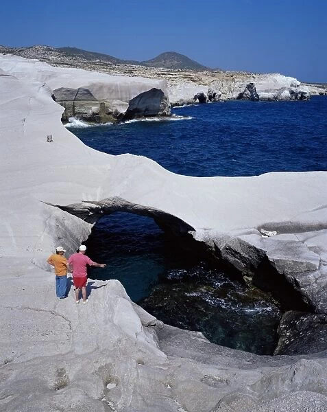 Tourists looking at Sarakiniko volcanic rock formations