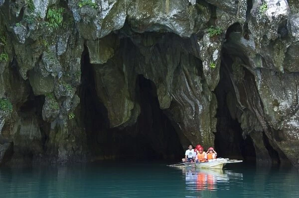 Tourists in paddle boat at entrance to Riverine Cave