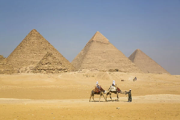 Tourists riding camels, Great Pyramids of Giza, UNESCO World Heritage Site, Giza, Egypt