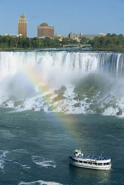 Tourists on small sightseeing boat below the American Falls on the Niagara River that flows between Lakes Erie and Ontario, Canada