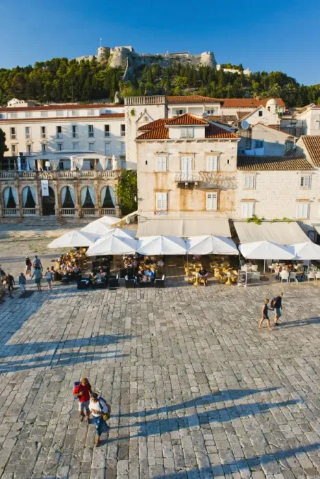 Framed Print : Tourists in St. Stephens Square, with the Spanish Fort (Fortica) above, Hvar Town, Hvar Island, Dalmatian Coast, Croatia, Europe Framed Print : Tourists in St. Stephens Square, with the Spanish Fort (Fortica) above, Hvar Town, Hvar Island, Dalmatian Coast, Croatia, Europe