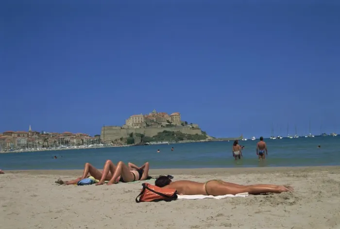 Framed Print : Tourists sunbathing on beach near Calvi, Balagne region, Corsica, France, Europe Framed Print : Tourists sunbathing on beach near Calvi, Balagne region, Corsica, France, Europe