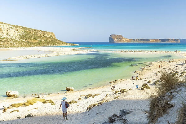 Tourists walking to the white sand beach surrounding Balos lagoon, Crete, Greek Islands