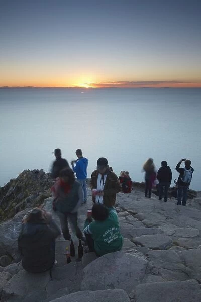 Tourists watching sunset from summit of Cerro Calvario, Copacabana, Lake Titicaca, Bolivia, South America