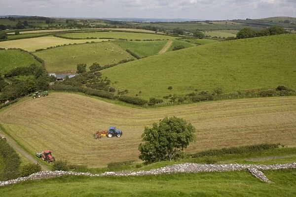 Tractors harvesting in field by Carreg Cennon, Brecon Beacons National Park