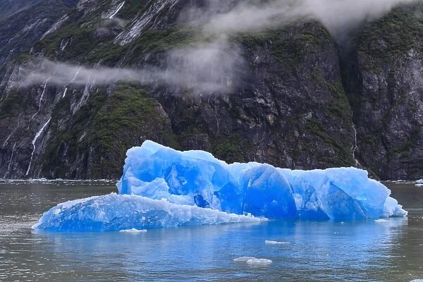 Tracy Arm Fjord, clearing mist, blue icebergs and cascades, near South Sawyer Glacier
