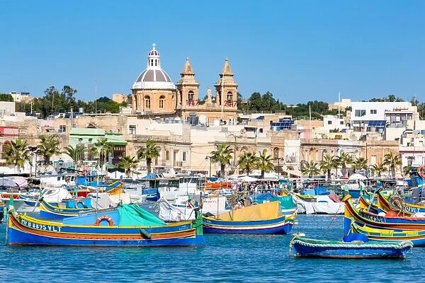 Traditional brightly painted fishing boats in the harbour at Marsaxlokk, Malta, Mediterranean