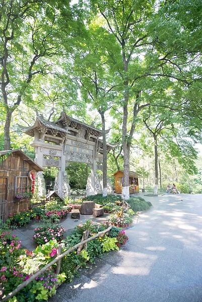 Traditional Chinese stone gate, lush surroundings and floral decorations at Wansong Academy