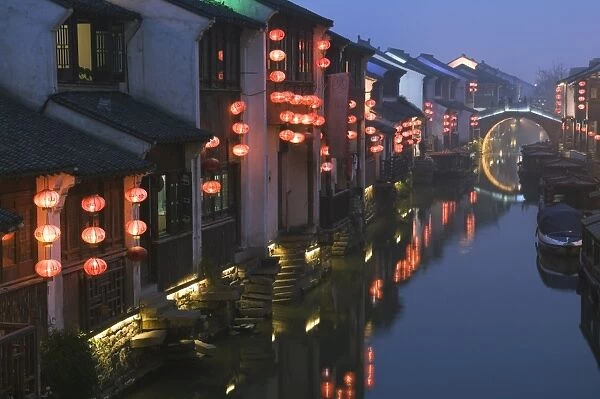 Traditional old riverside houses illuminated at night in Shantang water town
