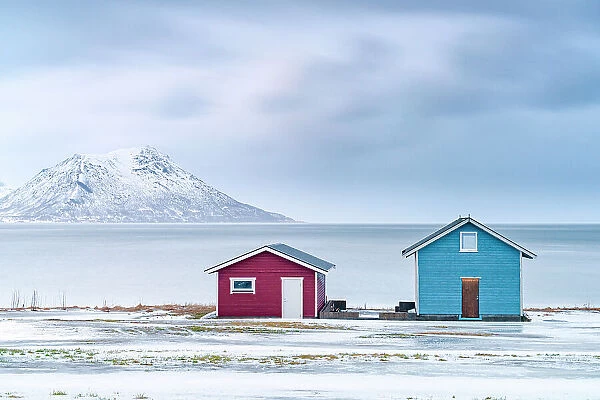 Traditional rorbu cabins overlooking the frozen sea, Troms county, Norway, Scandinavia, Europe