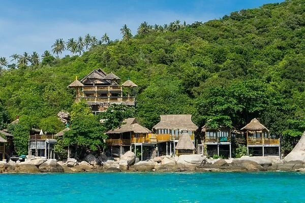 A traditional Thai resort overlooks turquoise water on the tropical island of Koh Tao