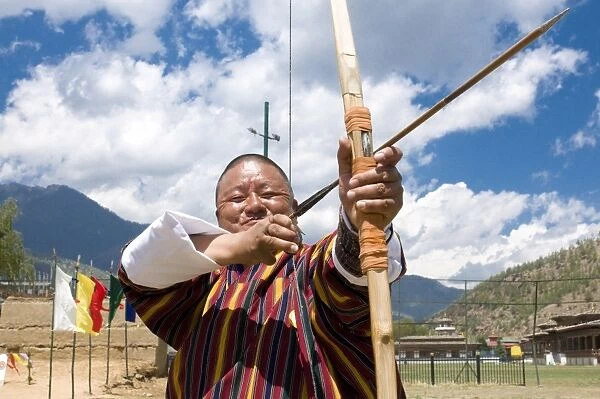 Traditionally dressed Bhutanese man practising the national sport of archery in the national stadium, Thimpu