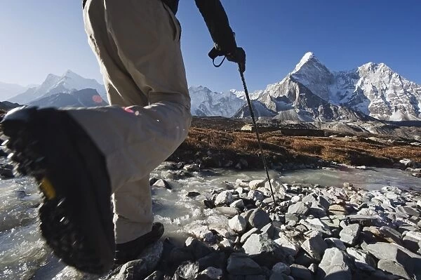 Trekker crossing a mountain stream, Ama Dablam, 6812m, Solu Khumbu Everest Region