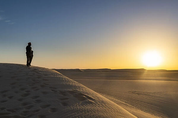 Tuareg standing on a sand dune in the Tenere Desert at sunrise, Sahara, Niger, Africa