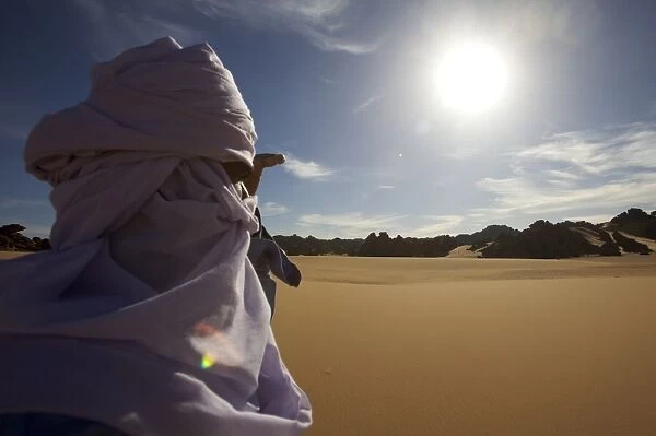 A Tuareg walking on a dune of the erg of Uan Kaza in the Fezzan desert