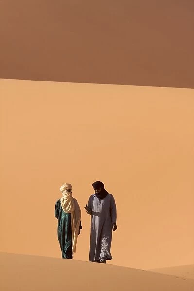 Two Tuaregs in the dunes of the erg of Murzuk in the Fezzan desert, Libya
