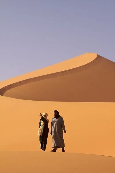 Two Tuaregs in the dunes of the erg of Murzuk in the Fezzan desert, Libya